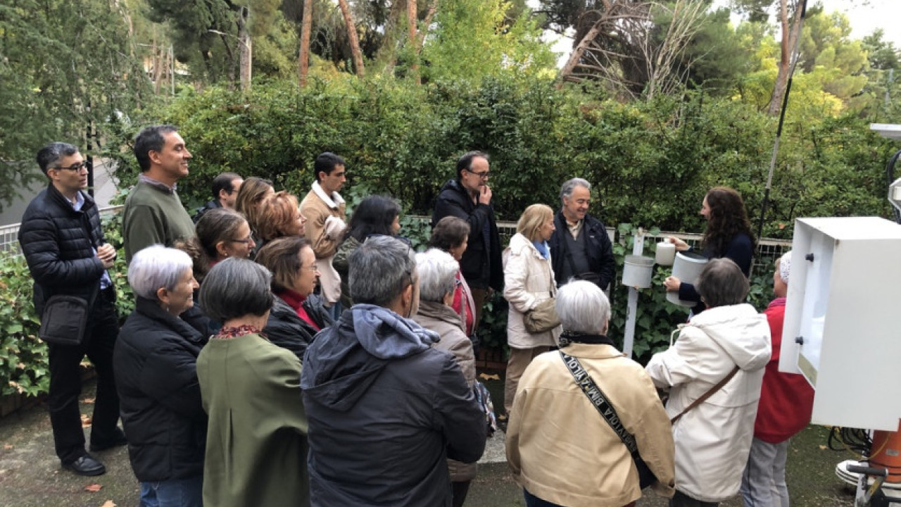 Una compañera de AEMET explica al público el funcionamiento de un pluviómetro.