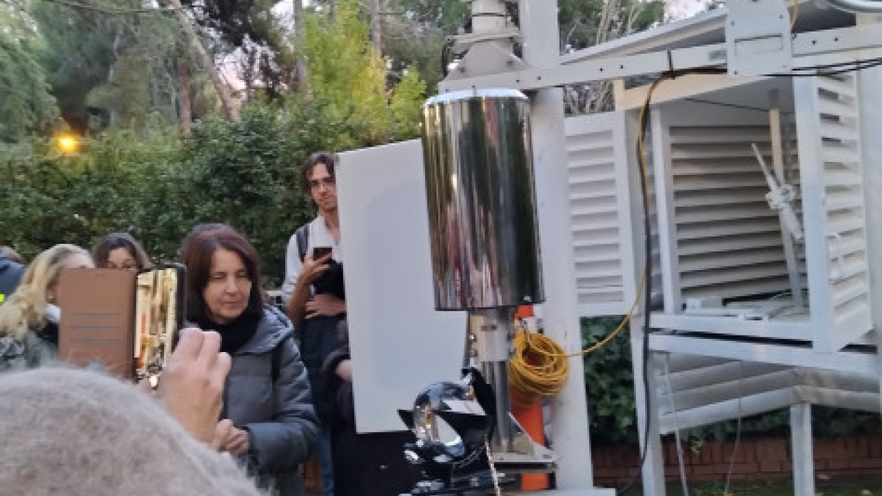 En la imagen se observa cómo algunas personas asistentes se interesan y toma  fotos del heliógrafo y del pluviómetro de balancín.