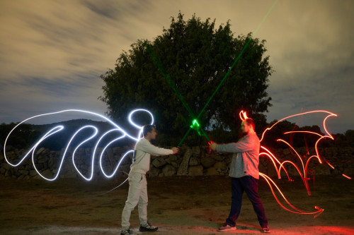 Light painting de un ángel y un demonio.